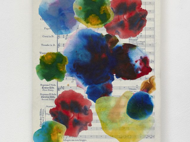 Colorful splashes of watercolor paint create depth and obscure a page from Midsummer Night's Dream