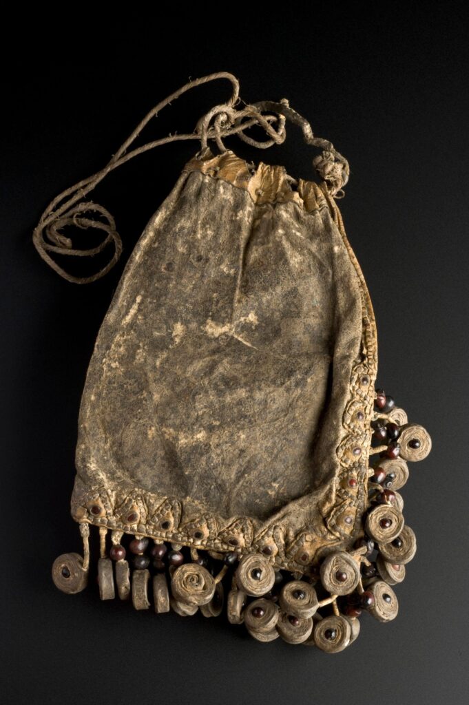 photo of a brown draw-string medicine bag. It has dangling embellishments made of natural materials.